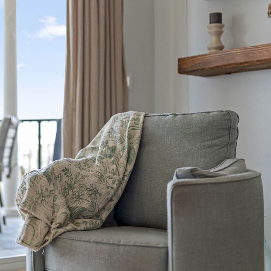 Armchair beside a bright window in a coastal rental