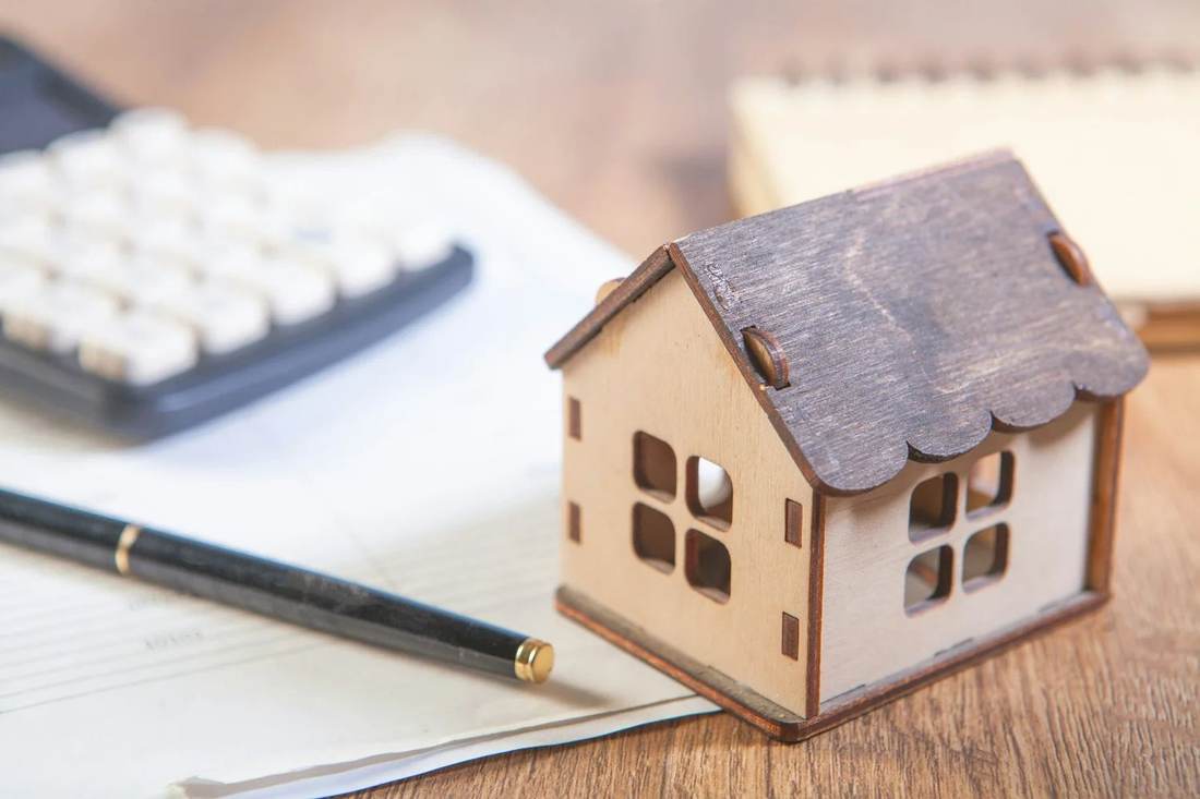 Model house beside a keyboard, representing real estate investment