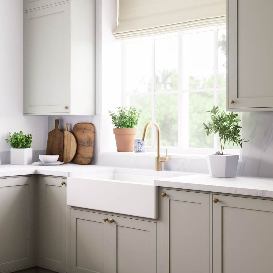 Bright kitchen sink beneath a window with potted plants